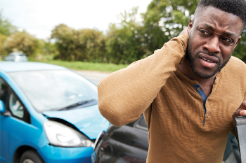 man hurt standing outside of car door after car crash