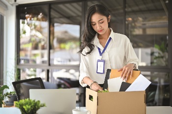 women packing up work supplies into a box