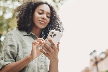 Black woman looking at phone in hands