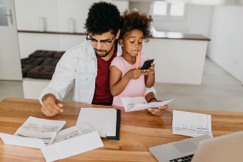 dad and daughter paying bills without automation
