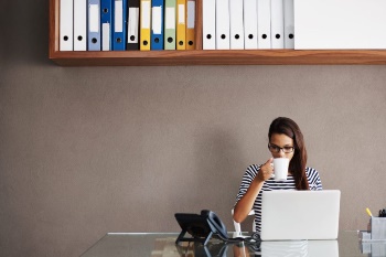 woman-sipping-coffee-at-her-desk