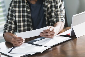 young man using the envelope method wishing he didn't have to use cash