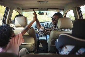 Dad and daughter clapping in the car