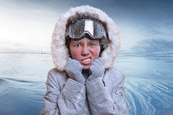 Woman in the snow with a parka on looking really cold and miserable