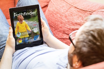 Guy laying on a couch reading Pathfinder on his tablet