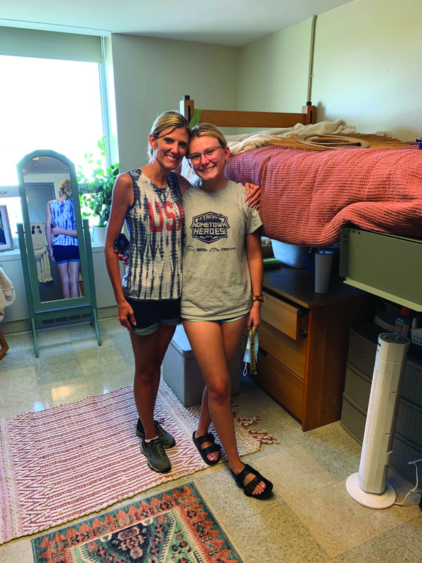Mother and daughter standing in dorm room
