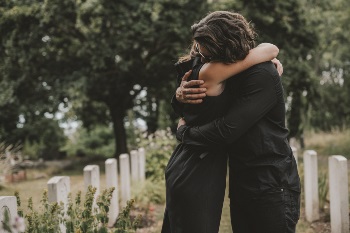 Man and women hugging at a funeral