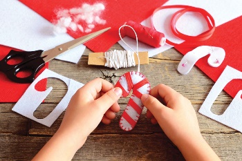 Child's hand holding candy cane craft