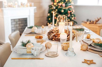 Simple holiday table setting with Christmas tree in the background