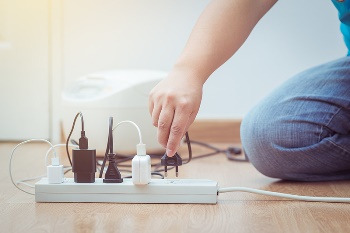 man plugging in to power strip
